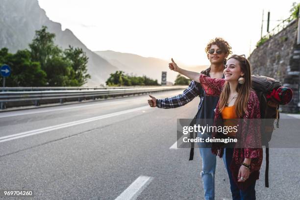 backpackers liften op de weg - lift stockfoto's en -beelden