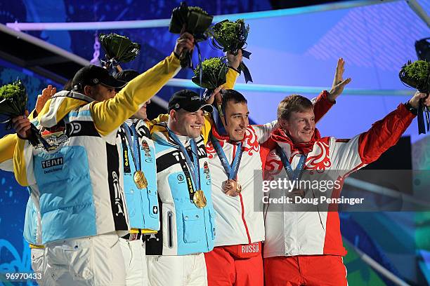 Richard Adjei and Thomas Florschuetz of Germany receive the silver medal, Kevin Kuske and Andre Lange of Germany receive the gold medal and Alexey...