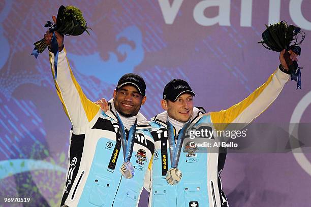 Richard Adjei and Thomas Florschuetz of Germany receive the silver medal during the medal ceremony for the men's two-man bobsleigh on day 11 of the...