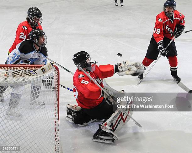 Md. -- 2/22/10 -- Glenelg goalie Tyler Hough makes a save as defensemen Chris Riciutti and Tyler Harrison fend off Walt Whitman's Lucas Karron in the...