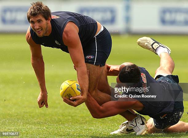 Jarrad Waite of the Blues handballs whilst being tackled by Mark Austin during a Carlton Blues AFL training session at Visy Park on February 23, 2010...