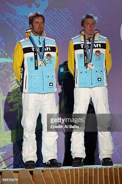 Axel Teichmann and Tim Tscharnke of Germany receive the silver medal during the medal ceremony for the men's team sprint cross-country skiing on day...