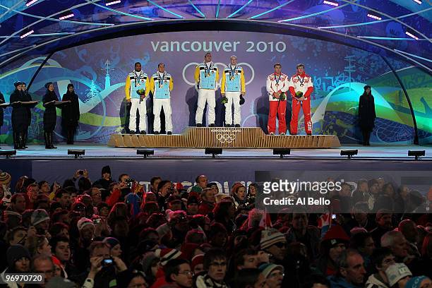 Richard Adjei and Thomas Florschuetz of Germany receive the silver medal, Kevin Kuske and Andre Lange of Germany receive the gold medal and Alexey...