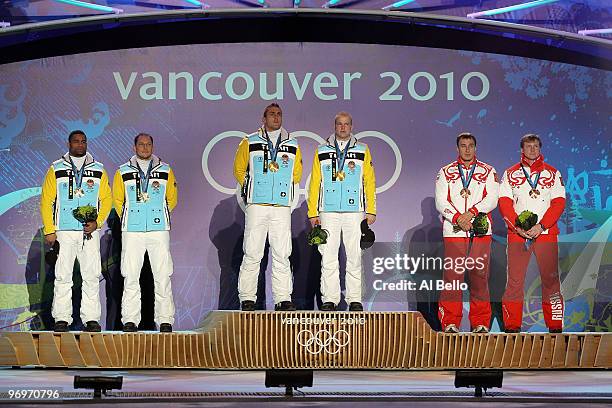 Richard Adjei and Thomas Florschuetz of Germany receive the silver medal, Kevin Kuske and Andre Lange of Germany receive the gold medal and Alexey...