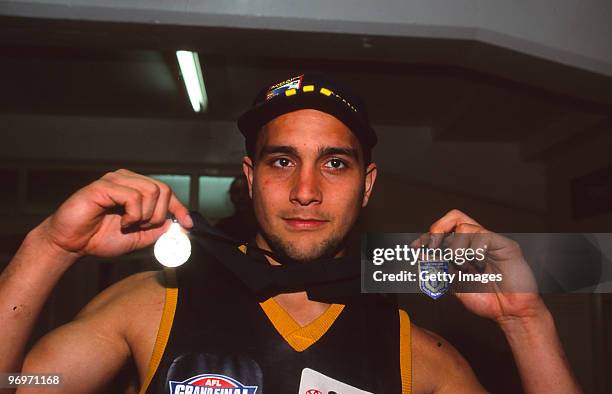 Andrew McLeod of the Crows holds up the Norm Smith medal and his Premiership medal after winning the 1998 AFL Grand Final between North Melbourne and...