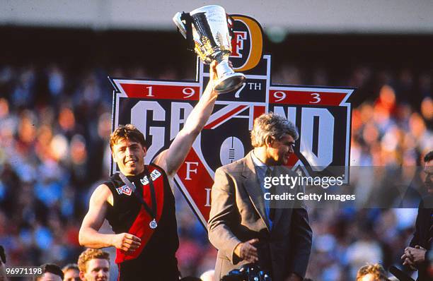 Mark Thompson of the Essendon Bombers holds aloft the premiership trophy after the 1993 AFL Grand Final between Essendon and Carlton in Melbourne,...