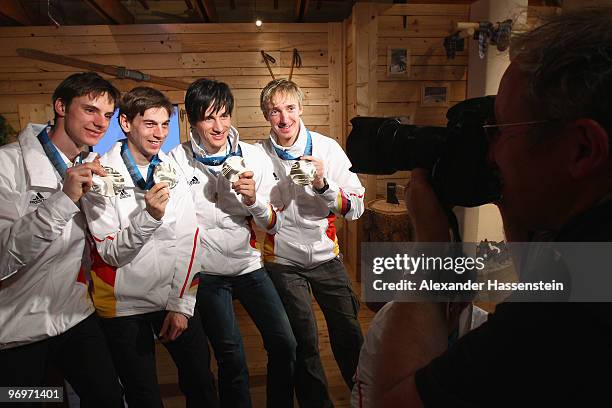 The German team of Andreas Wank, Michael Neumayer, Martin Schmitt and Michael Uhrmann pose with the silver medal for the men's team ski jumping on...