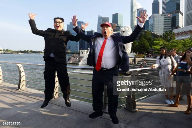 Kim Jong-un impersonator, Howard X and Donald Trump impersonator, Dennis Alan do a jump shot at Merlion Park on June 8, 2018 in Singapore. The White...