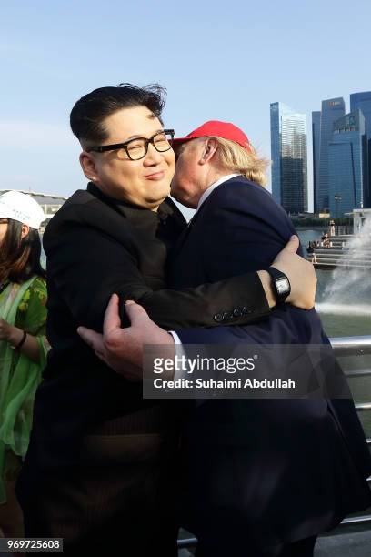 Kim Jong-un impersonator, Howard X and Donald Trump impersonator, Dennis Alan shares a hug at Merlion Park on June 8, 2018 in Singapore. The White...