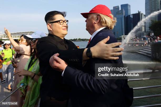 Kim Jong-un impersonator, Howard X and Donald Trump impersonator, Dennis Alan shares a hug at Merlion Park on June 8, 2018 in Singapore. The White...