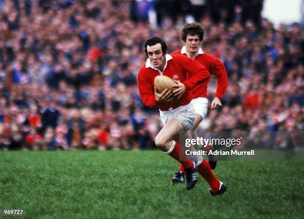 Phil Bennett of Llanelli runs with the ball during the Rugby Union International Friendly match against New Zealand to commerate the Welsh Centenary...