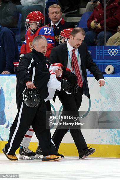 Darcia Leimgruber of Switzerland is assited off the ice after she was knocked out on a check during the ice hockey women's classification 5th/6th...