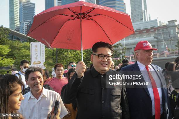 Kim Jong Un impersonator, Howard X and Donald Trump impersonator Dennis Alan walk around greeting people during a visit to the famous Merlion Park on...