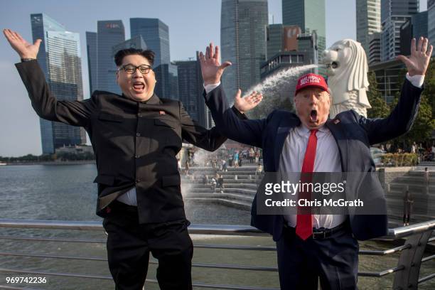Kim Jong Un impersonator, Howard X and Donald Trump impersonator Dennis Alan pose for photographers during a visit to the famous Merlion Park on June...