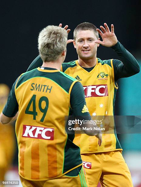 Steven Smith of Australia is congratulated by captain Michael Clarke after he took a catch during the Twenty20 International match between Australia...