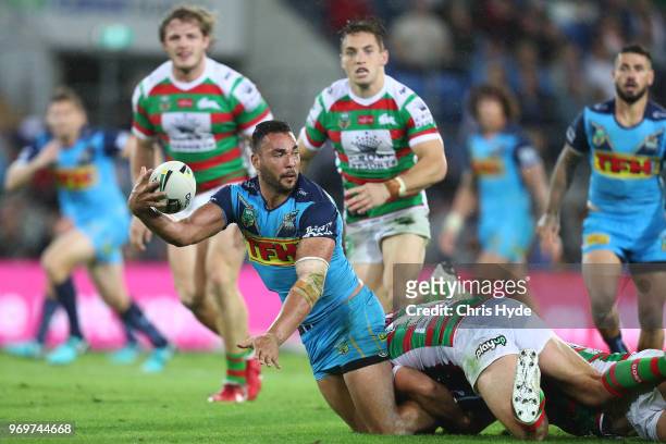 Ryan James of the Titans passes while tackled during the round 14 NRL match between the Gold Coast Titans and the South Sydney Rabbitohs at Cbus...