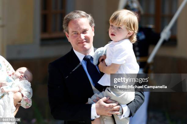 Christopher O'neill holding Prince Nicolas of Sweden pose after the christening of Princess Adrienne of Sweden at Drottningholm Palace Chapel on June...