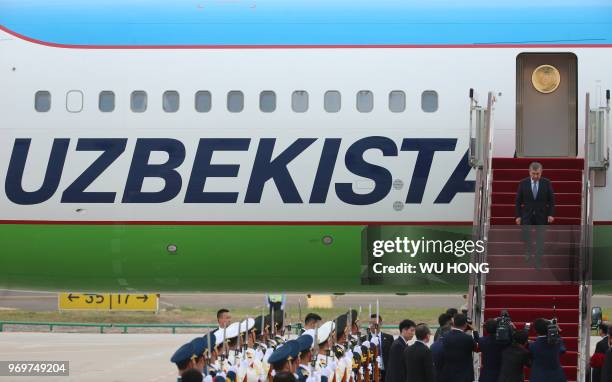 Uzbekistan President Shavkat Mirziyoyev walks out from the airplane upon his arrival at Qingdao Liuting International Airport in Qingdao, China's...