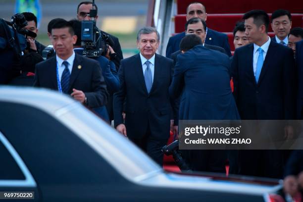 Uzbekistan President Shavkat Mirziyoyev walks to his car after walking out from the airplane upon his arrival at Qingdao Liuting International...