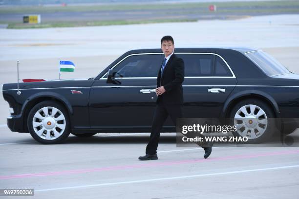 The car carrying Uzbekistan President Shavkat Mirziyoyev drives out of Qingdao Liuting International Airport for the 18th Shanghai Cooperation...