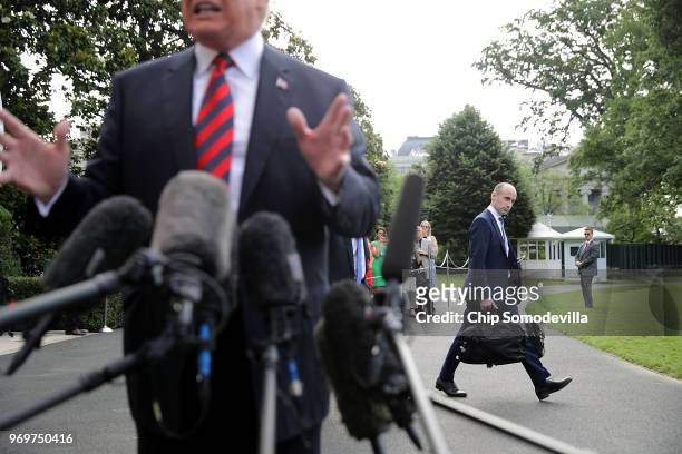 Senior Advisor to the President Stephen Miller walks behind U.S. President Donald Trump as he talks to reporters before they depart the White House...