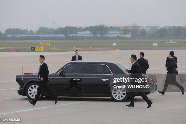 Chinese guard personnel guards follow the car of Uzbekistan President Shavkat Mirziyoyev after he arrived at Qingdao Liuting International Airport...