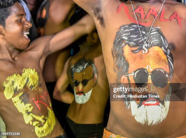 Fans of Bollywood actor Rajinikanth displaying body paint with a portrait of the actor as they dance on the first day of release of his new film...