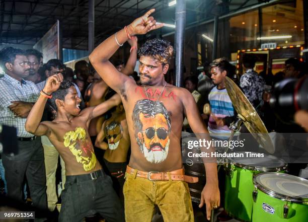 Fans of Bollywood actor Rajinikanth displaying body paint with a portrait of the actor as they dance on the first day of release of his new film...