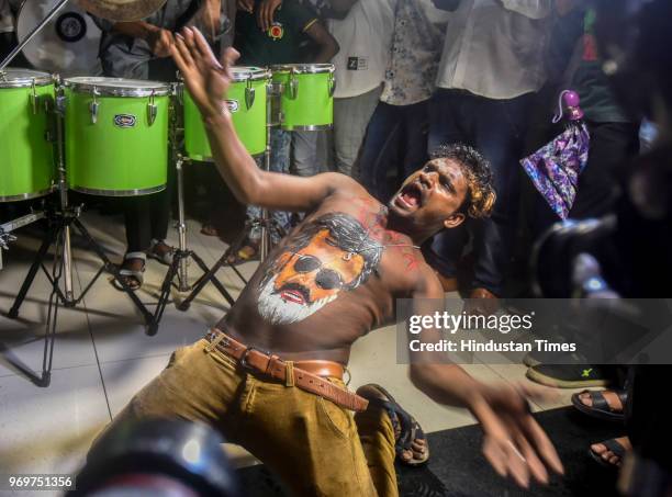 Fans of Bollywood actor Rajinikanth displaying body paint with a portrait of the actor as they dance on the first day of release of his new film...