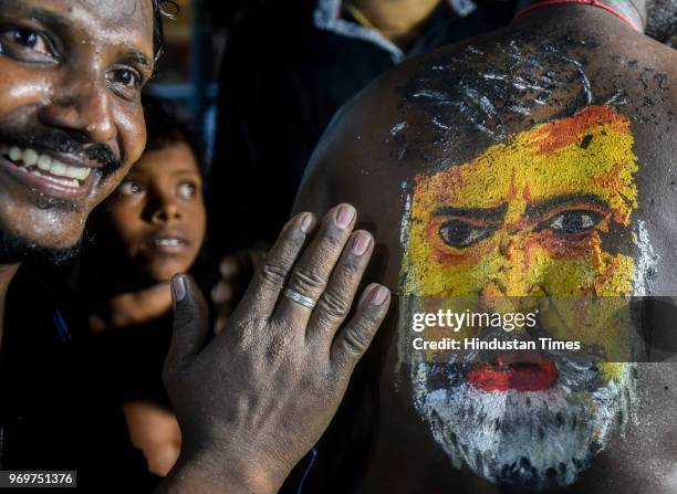 Fans of Bollywood actor Rajinikanth displaying body paint with a portrait of the actor as they dance on the first day of release of his new film...