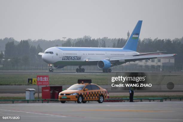 The plane carrying Uzbekistan President Shavkat Mirziyoyev lands at Qingdao Liuting International Airport as he arrives to attend the 18th Shanghai...