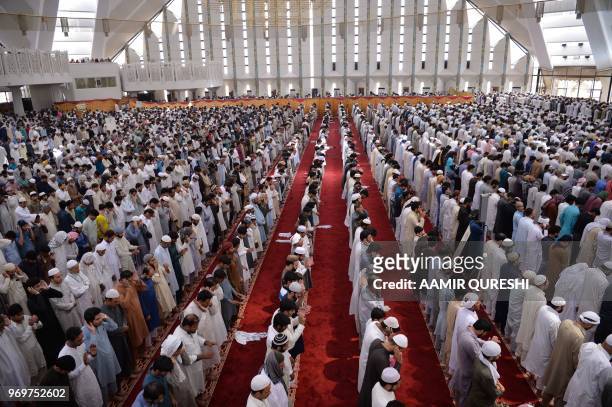Pakistani Muslims offer prayers on the last Friday of the holy month of Ramadan at the grand Faisal Mosque in Islamabad on June 8, 2018. - Muslims...