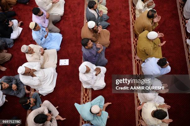 Pakistani Muslims offer prayers on the last Friday of the holy month of Ramadan at the grand Faisal Mosque in Islamabad on June 8, 2018. - Muslims...