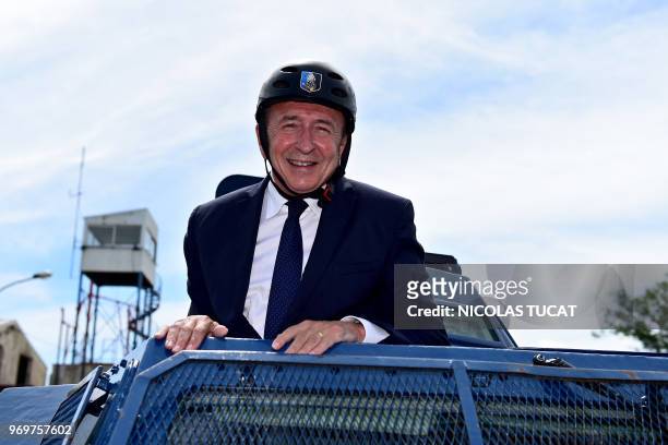 French Interior Minister Gerard Collomb stands in an armoured vehicle during a visit at the French Gendarmerie national training centre , on June 8...