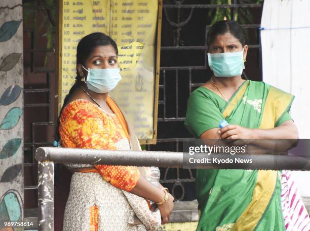 Women wearing protective masks are pictured in Kozhikode in the state of Kerala, southern India, on June 7 following an outbreak of the deadly Nipah...