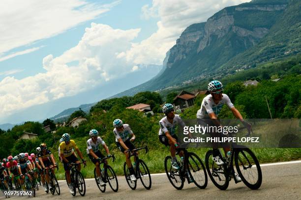 Members of Great Britain's Sky cycling team, with Italy's Gianni Moscon, wearing the overall leader's yellow jersey lead the pack chasing a breakaway...