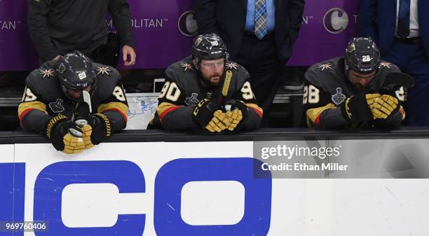 Alex Tuch, Tomas Tatar and William Carrier of the Vegas Golden Knights sit on the bench as they watch the Washington Capitals celebrate their 4-3 win...