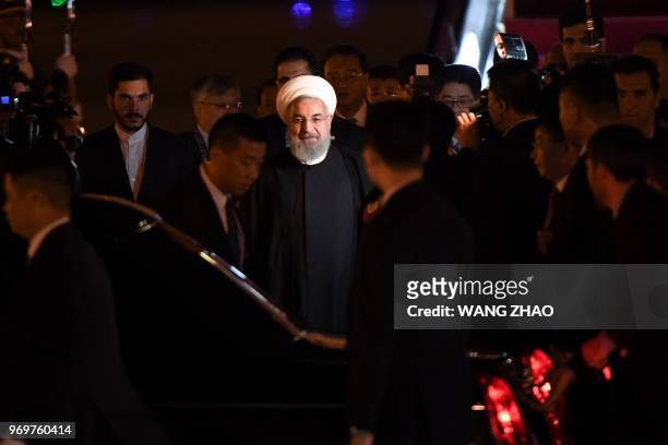 Iranian President Hassan Rouhani walks to his car after walking out from the airplane upon his arrival at Qingdao Liuting International Airport in...
