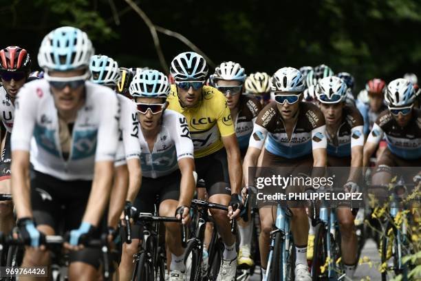 The pack, with Italy's Gianni Moscon , wearing the overall leader's yellow jersey, and his Great Britain's Sky cycling team partners, chases a...