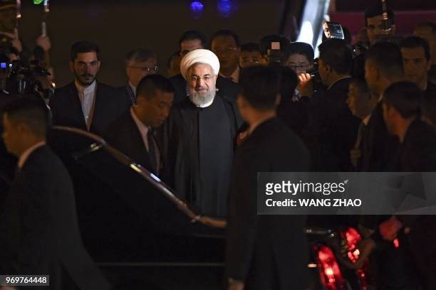 Iranian President Hassan Rouhani walks to his car upon his arrival at Qingdao Liuting International Airport in Qingdao, China's Shandong province on...