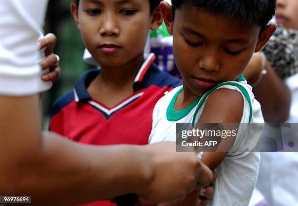 Filipino nurse injects a boy with a measles vaccine in a slum area in Tondo, Manila, on February 23, 2010. The Department of Health has declared an...