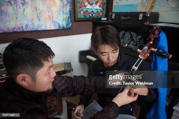 Morin Khuur teacher works with a student at Mongol Khuur Center in Ulaanbaatar, Mongolia. The Morin Khuur, or horsehead fiddle, is a traditional...