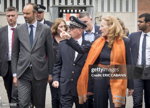 French Prime Minister Edouard Philippe and French Justice Minister Nicole Belloubet speaks with prison director Jean-Paul Ruffenach as they arrive to...