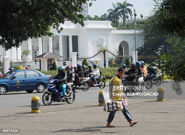 Pedestrians and vehicles pass in front of the presidential palace in Jakarta on February 23, 2010. It has been the economic heartbeat of the world's...