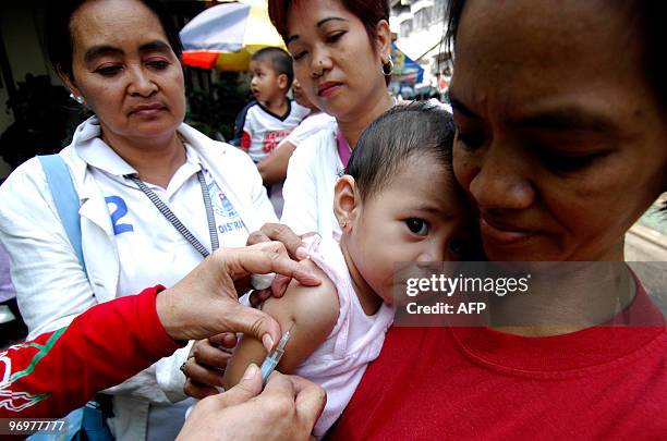 Filipino nurse injects an infant with a measles vaccine in a slum area in Tondo, Manila, on February 23, 2010. The Department of Health has declared...