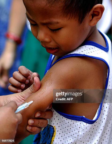 Filipino nurse injects a boy with a measles vaccine in a slum area in Tondo, Manila, on February 23, 2010. The Department of Health has declared an...