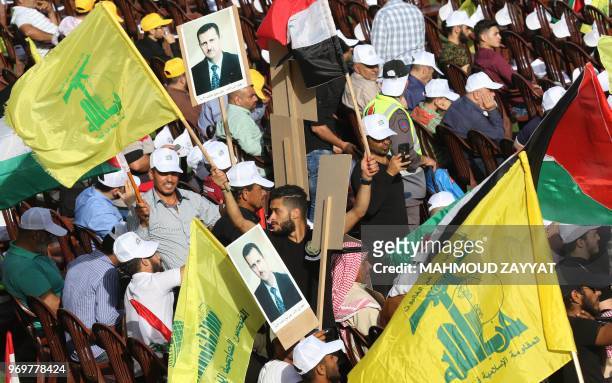 Lebanese Shiite Muslims carry pictures of Syrian president Bachar al-Assad, flags of the Lebanese Shiite Hezbollah movement as well as a Palestinian...