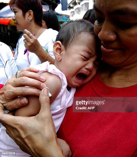 An infant cries after receiving a measles vaccination injection in a slum area in Tondo, Manila, on February 23, 2010. The Department of Health has...