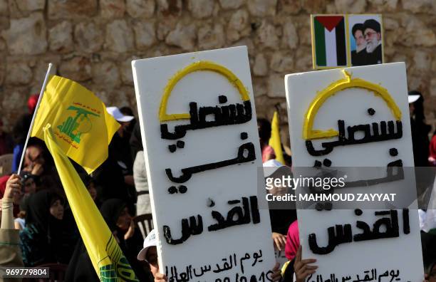 Lebanese Shiite Muslims carry banners that read in Arabic 'we will pray in Jerusalem' as well as flags of the Lebanese Shiite Hezbollah movement...