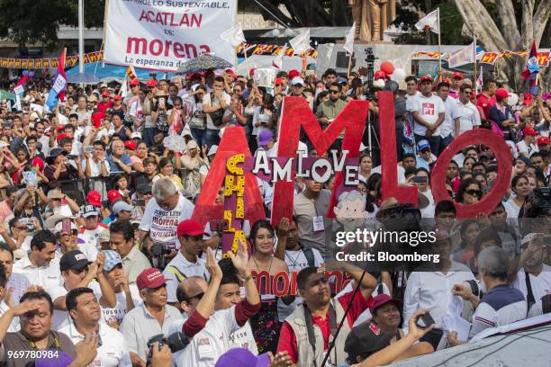 Supporters hold signs while Andres Manuel Lopez Obrador, presidential candidate of the National Regeneration Movement Party , not pictured, speaks...